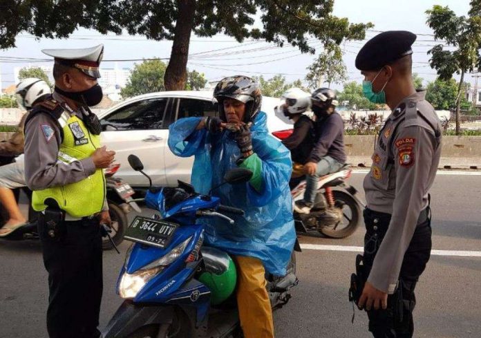 Ilustrasi pemeriksaan petugas kepolisian kepada pengguna motor.