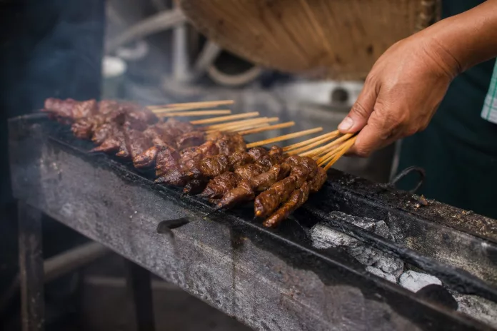Resep Sate Sapi Empuk dan Bumbu Meresap Sate sapi empuk dengan bumbu meresap disajikan di atas piring dengan lontong dan sambal kacang