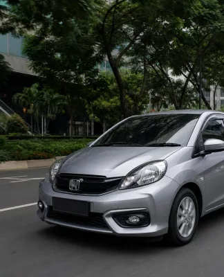 Perbandingan city car dan hatchback di jalan perkotaan yang padat, menunjukkan ukuran dan kepraktisan kedua mobil