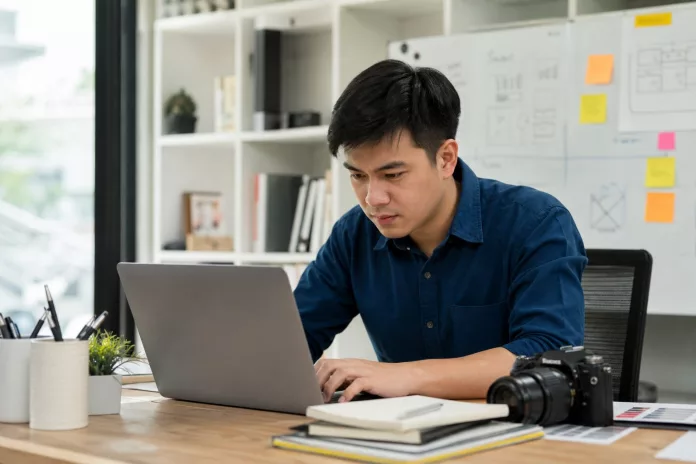 Daftar Ucapan Perpisahan Kerja di Grup WhatsApp, Singkat dan Berkesan! Seorang copywriter sedang bekerja di depan laptop menulis konten kreatif dan persuasif