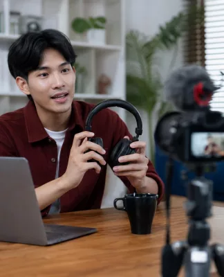 Content Creator vs Influencer, Apa Bedanya? Content creator sedang membuat konten digital di depan kamera dan laptop, berbeda dengan influencer